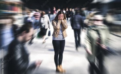 The new gene may help control the way the brain responds to fear. Adobe Woman standing with head in hands in middle of busy city. Adobe